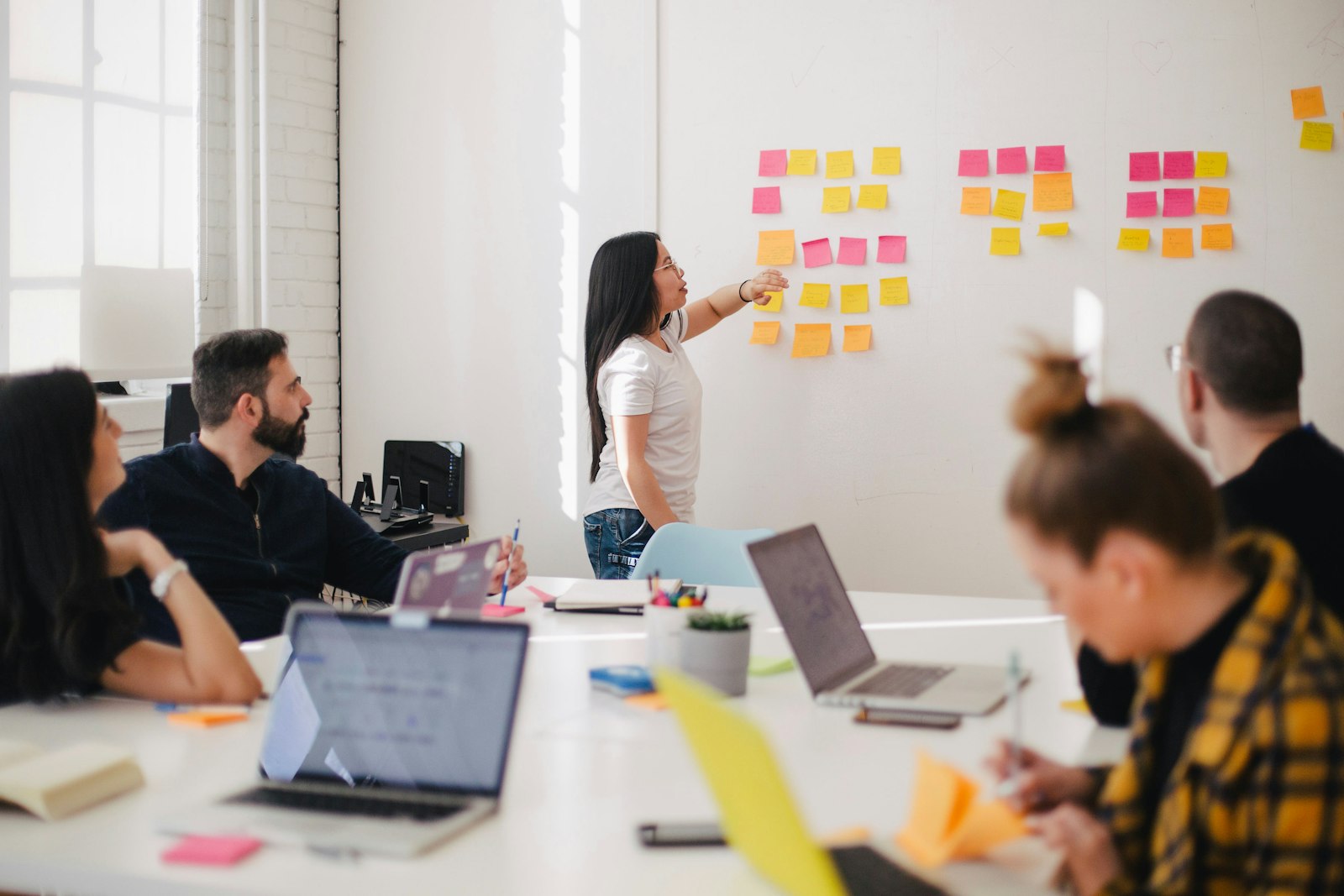 Small team planning a website redesign with sticky notes on a wall